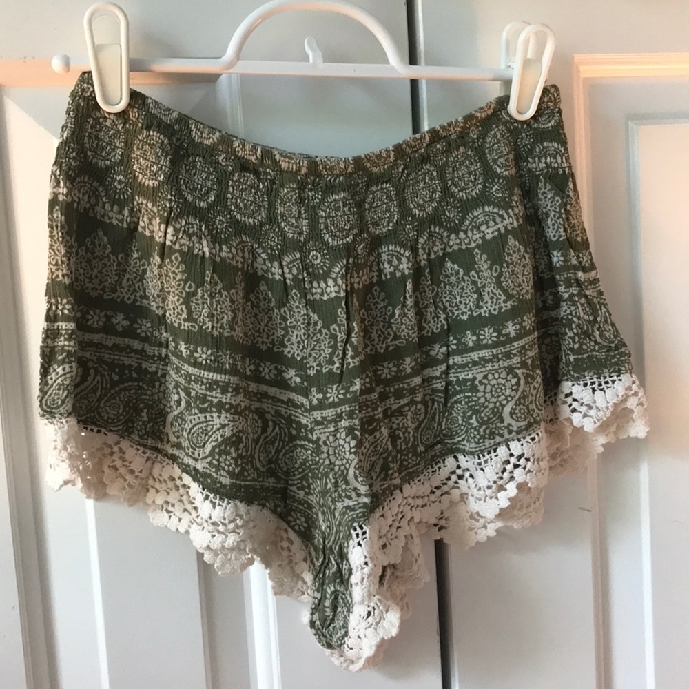 Green shorts with cream color lace bottoms.